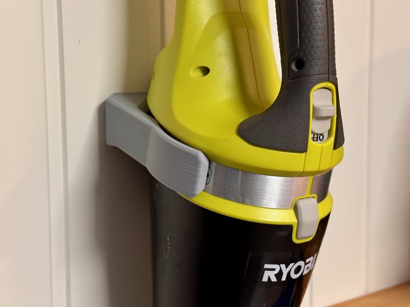 3D-printed wall bracket holding a Ryobi handheld vacuum
